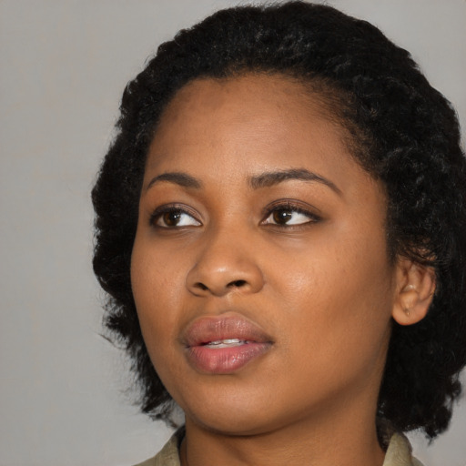 Joyful black young-adult female with medium  black hair and brown eyes