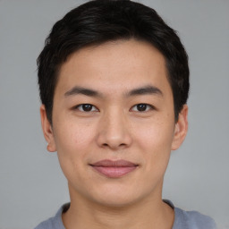 Joyful asian young-adult male with short  brown hair and brown eyes