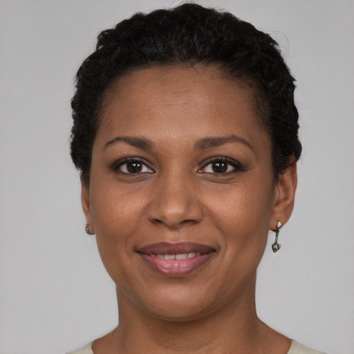 Joyful black young-adult female with short  black hair and brown eyes