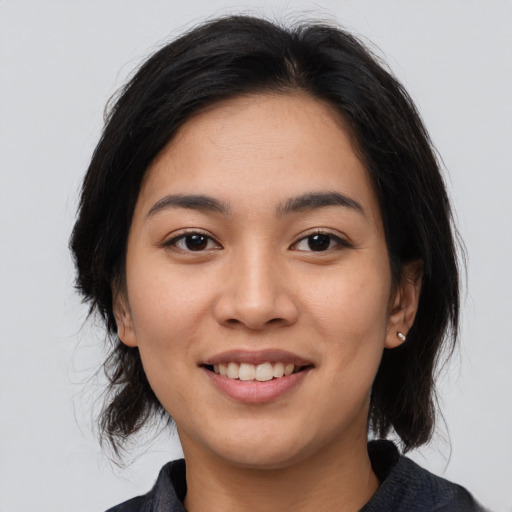 Joyful asian young-adult female with medium  black hair and brown eyes