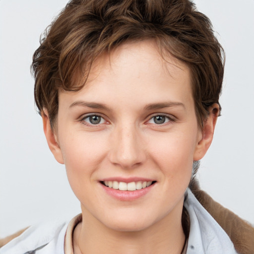 Joyful white young-adult female with short  brown hair and grey eyes