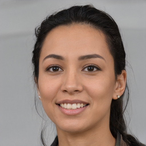 Joyful latino young-adult female with long  brown hair and brown eyes