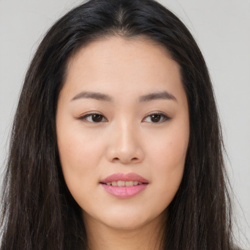 Joyful asian young-adult female with long  brown hair and brown eyes