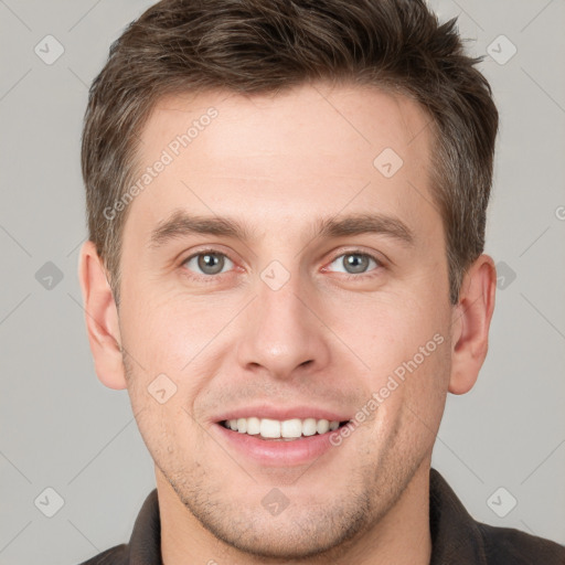 Joyful white young-adult male with short  brown hair and grey eyes