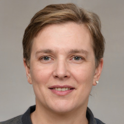 Joyful white adult female with medium  brown hair and grey eyes