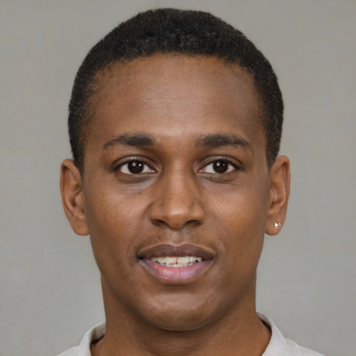 Joyful black young-adult male with short  brown hair and brown eyes