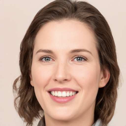 Joyful white young-adult female with medium  brown hair and green eyes