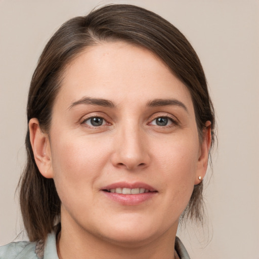 Joyful white young-adult female with medium  brown hair and grey eyes