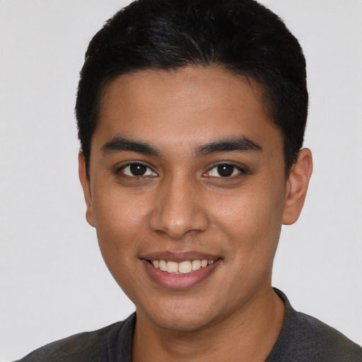 Joyful latino young-adult male with short  black hair and brown eyes