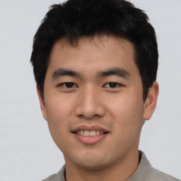 Joyful asian young-adult male with short  black hair and brown eyes