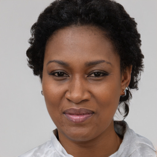 Joyful black adult female with short  black hair and brown eyes