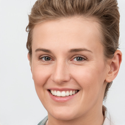 Joyful white young-adult female with short  brown hair and grey eyes