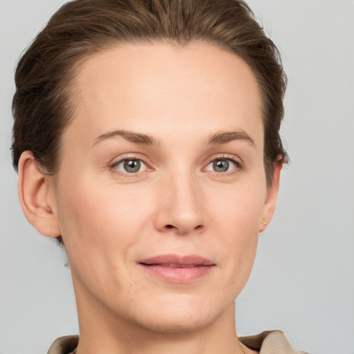 Joyful white young-adult female with short  brown hair and grey eyes