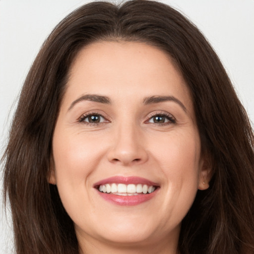 Joyful white young-adult female with long  brown hair and brown eyes