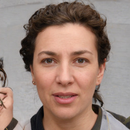 Joyful white adult female with medium  brown hair and blue eyes