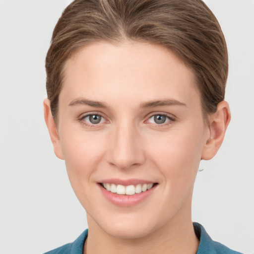 Joyful white young-adult female with short  brown hair and grey eyes