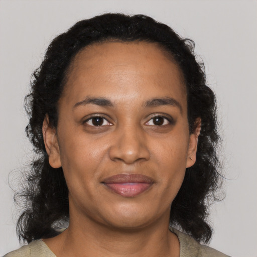 Joyful black adult female with long  black hair and brown eyes