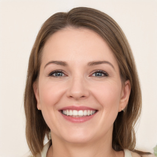 Joyful white young-adult female with medium  brown hair and grey eyes