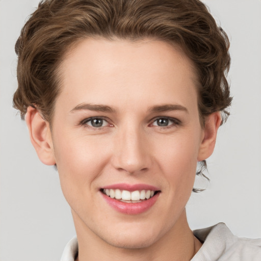 Joyful white young-adult female with short  brown hair and green eyes