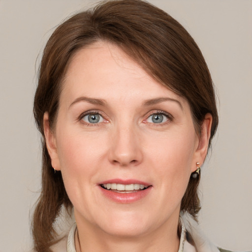 Joyful white adult female with medium  brown hair and blue eyes