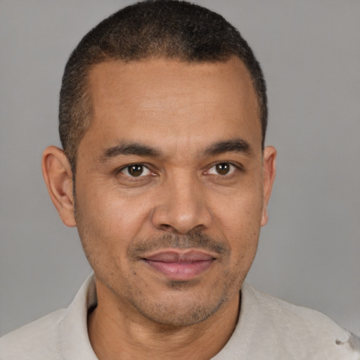 Joyful latino adult male with short  brown hair and brown eyes