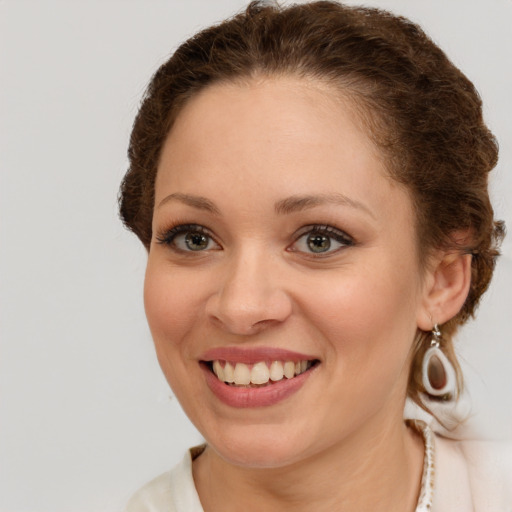 Joyful white young-adult female with short  brown hair and green eyes