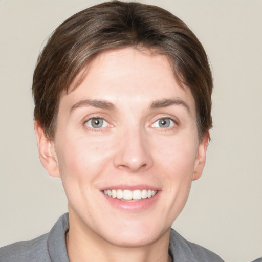 Joyful white young-adult female with short  brown hair and grey eyes