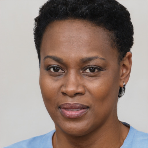 Joyful black young-adult female with short  black hair and brown eyes