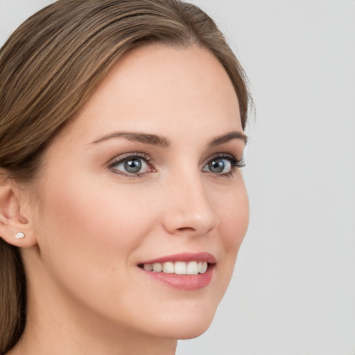 Joyful white young-adult female with long  brown hair and grey eyes