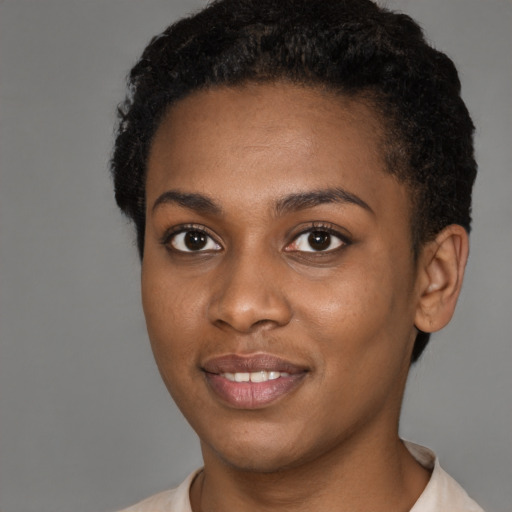 Joyful black young-adult female with short  brown hair and brown eyes