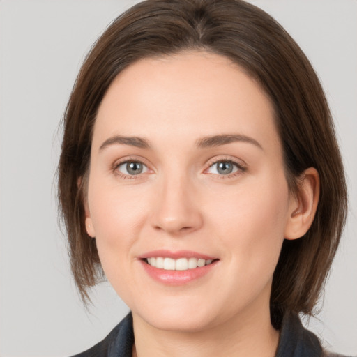 Joyful white young-adult female with medium  brown hair and grey eyes