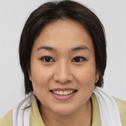 Joyful asian young-adult female with medium  brown hair and brown eyes