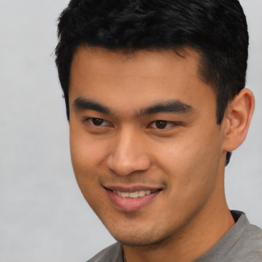 Joyful latino young-adult male with short  black hair and brown eyes