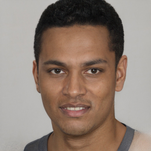 Joyful black young-adult male with short  black hair and brown eyes
