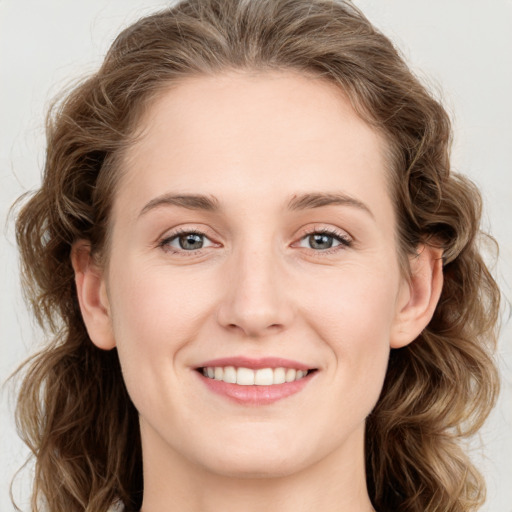 Joyful white young-adult female with long  brown hair and blue eyes