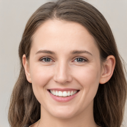 Joyful white young-adult female with long  brown hair and grey eyes