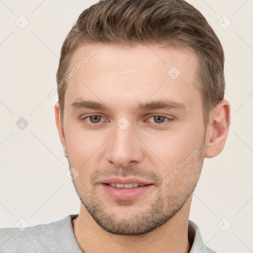 Joyful white young-adult male with short  brown hair and grey eyes