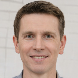 Joyful white adult male with short  brown hair and grey eyes