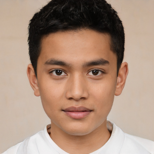 Joyful latino child male with short  black hair and brown eyes