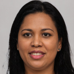 Joyful latino young-adult female with long  black hair and brown eyes