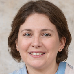 Joyful white adult female with medium  brown hair and grey eyes