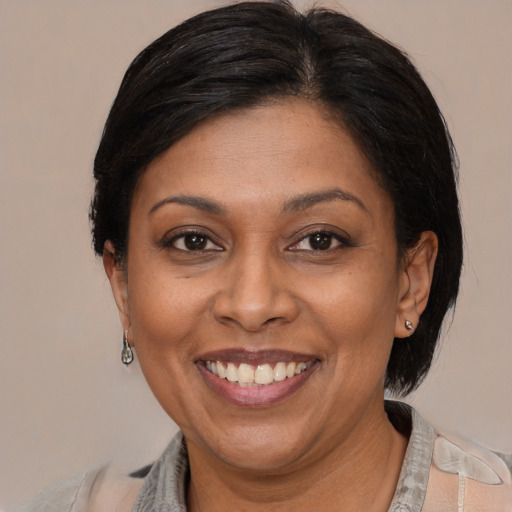 Joyful latino adult female with medium  brown hair and brown eyes