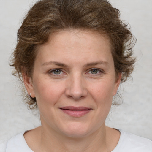 Joyful white adult female with medium  brown hair and blue eyes