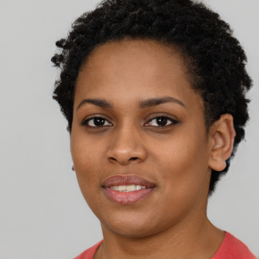 Joyful black young-adult female with short  brown hair and brown eyes