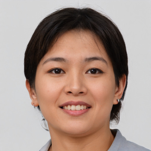 Joyful asian young-adult female with short  brown hair and brown eyes