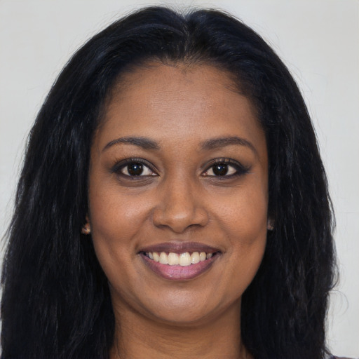 Joyful black young-adult female with long  brown hair and brown eyes