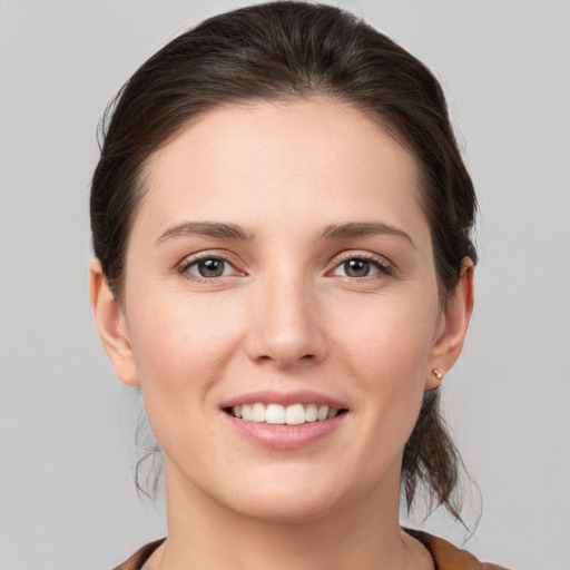 Joyful white young-adult female with medium  brown hair and grey eyes