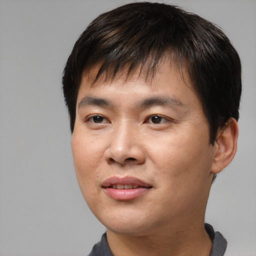 Joyful asian young-adult male with short  brown hair and brown eyes