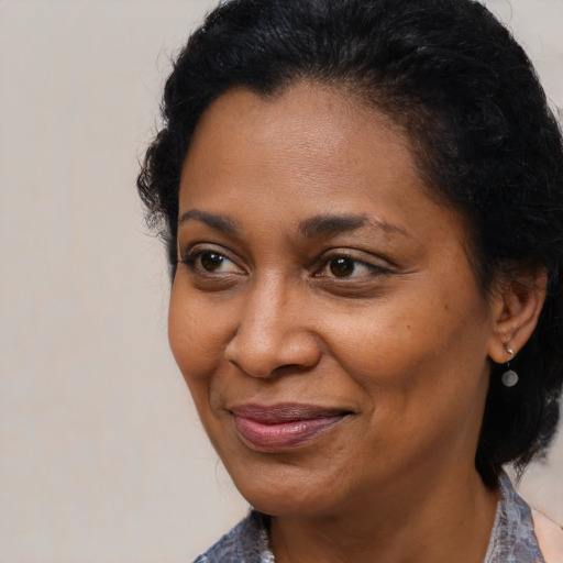 Joyful black adult female with medium  brown hair and brown eyes