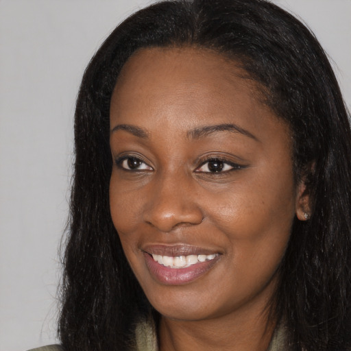 Joyful black young-adult female with long  black hair and brown eyes